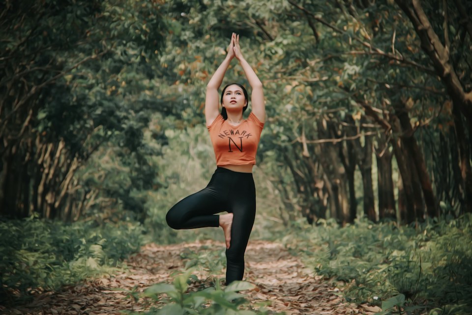 Practicing yoga outdoors among trees